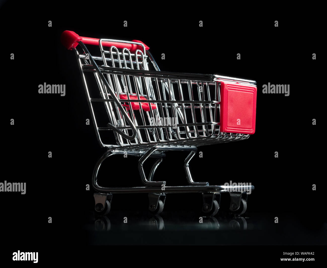 Miniature shopping cart on black background Stock Photo