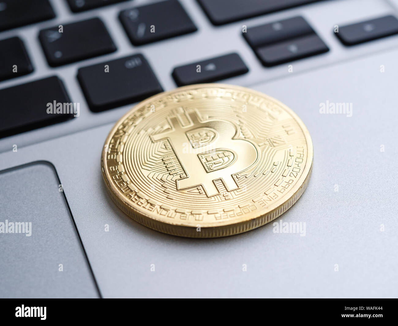 Golden bitcoin coin on laptop, shallow depth of field Stock Photo