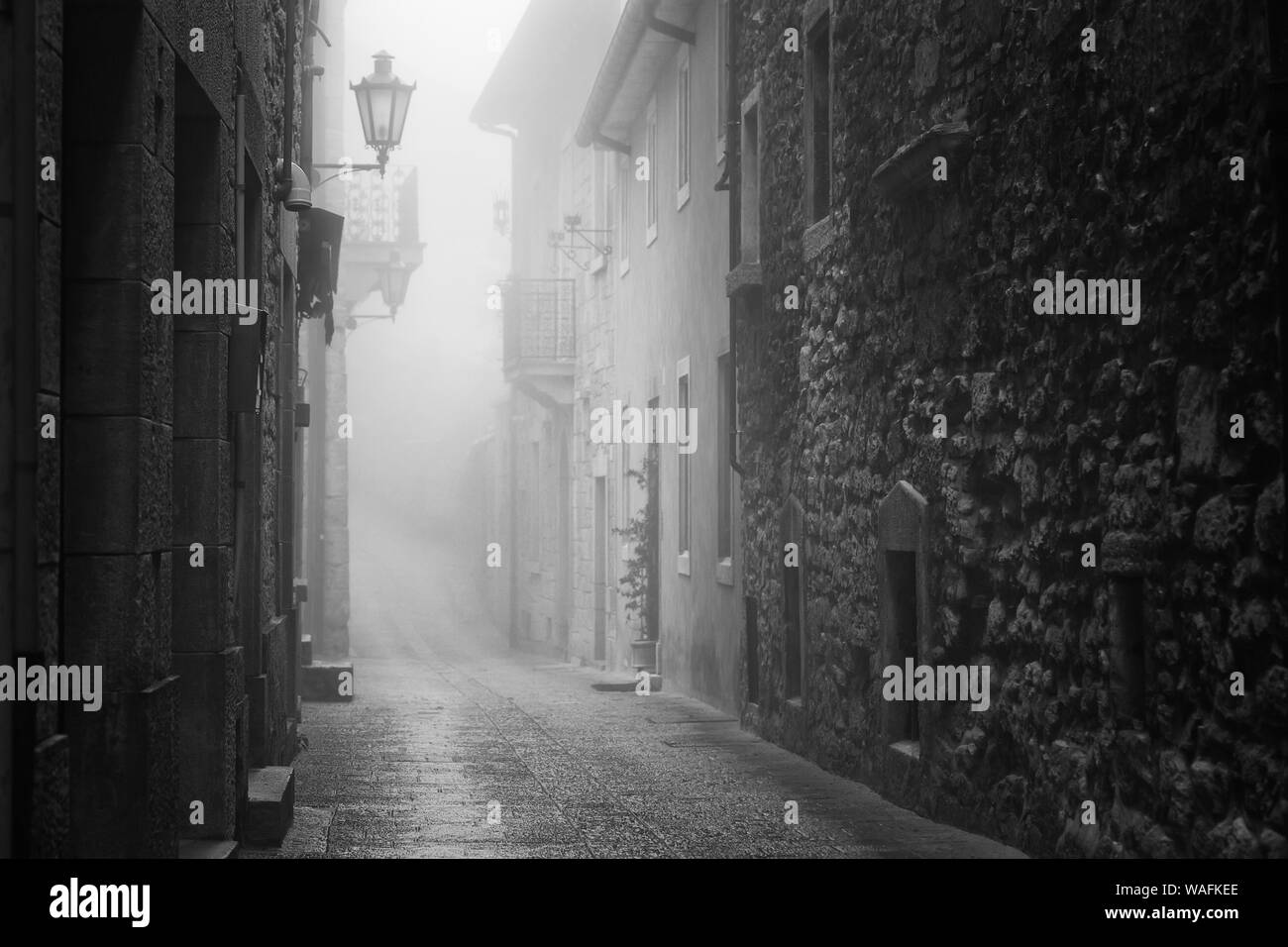 Old narrow street of San Marino during foggy weather Stock Photo