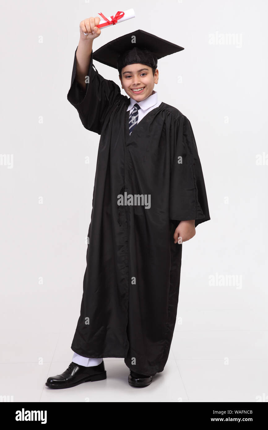 Boy in graduation gown showing a degree Stock Photo