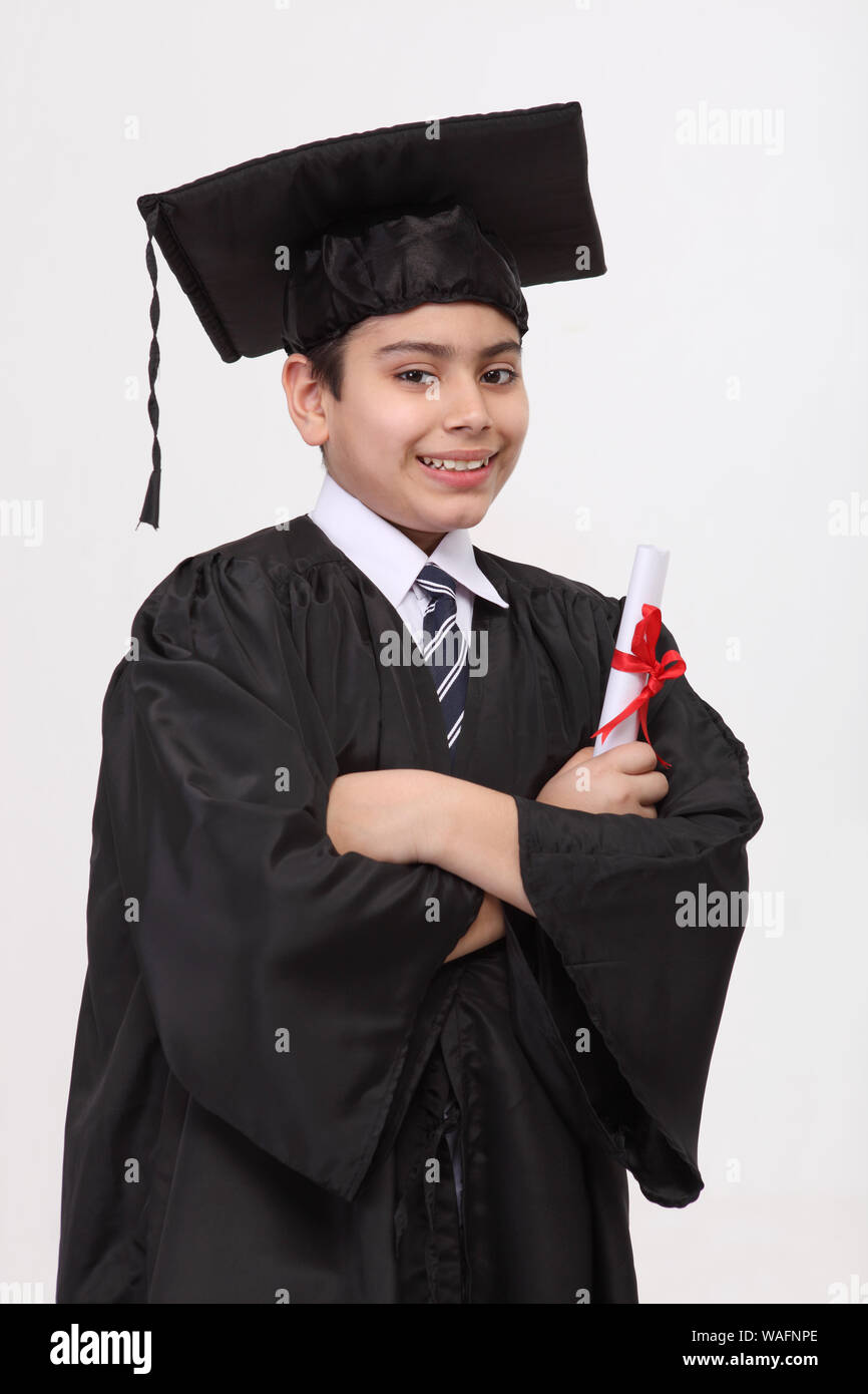 Boy in graduation gown holding a degree Stock Photo