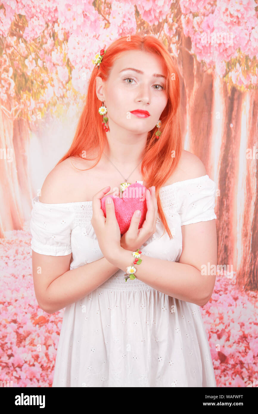 pretty lovely redheaded woman with pink plush heart toy Stock Photo Alamy