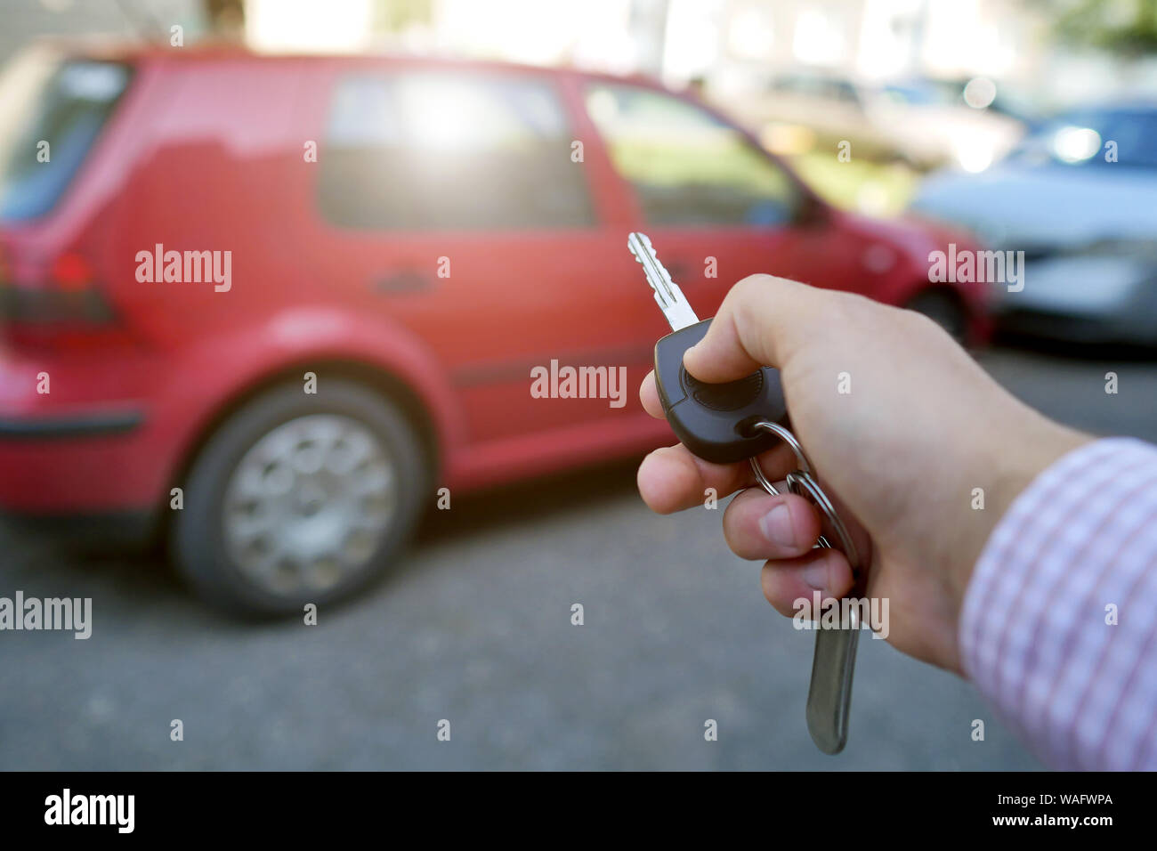 key in hand on blurred car background Stock Photo - Alamy