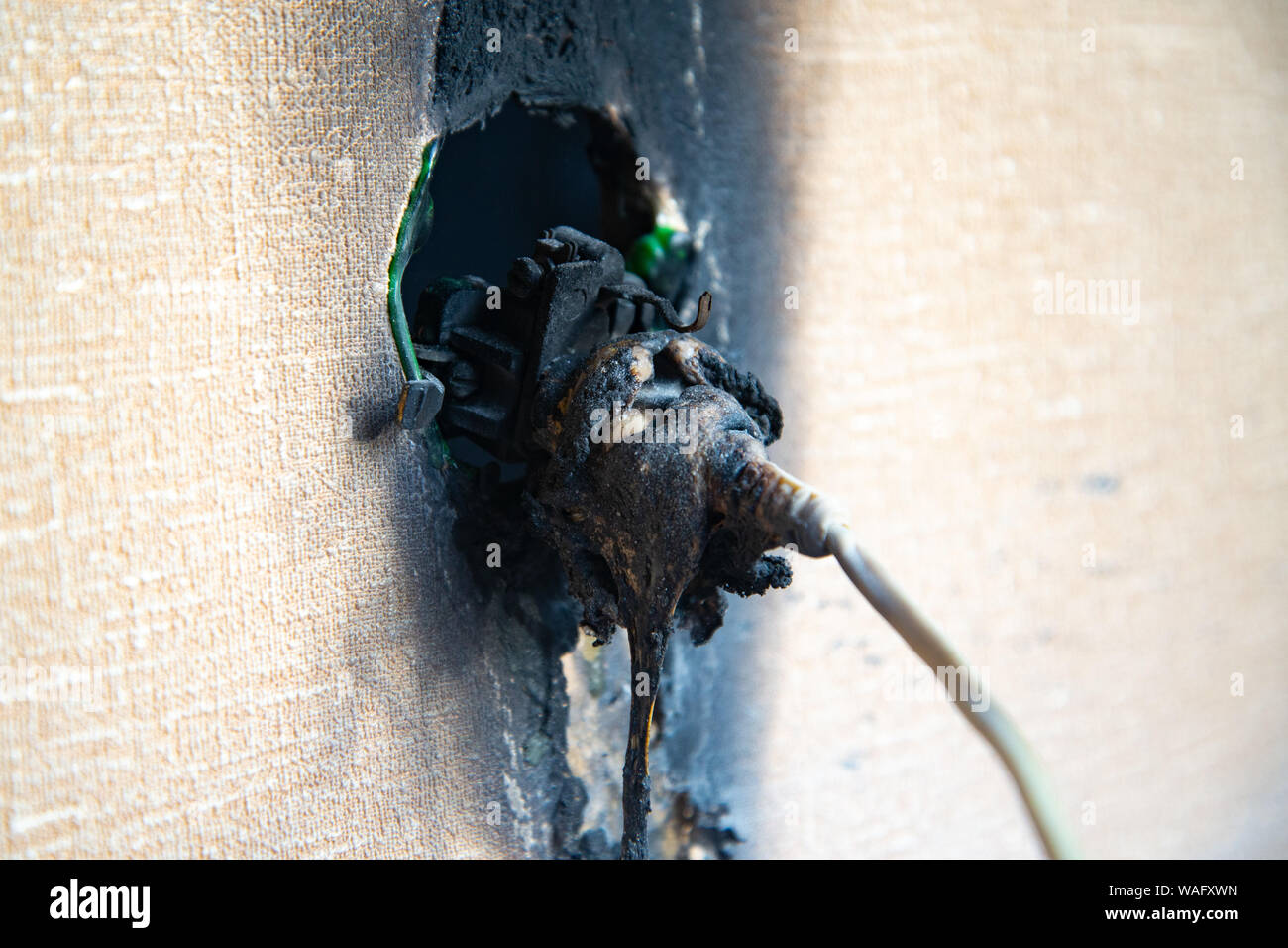 Burnt power outlet. Melted-off and burned plastic socket of power supply. Stock Photo