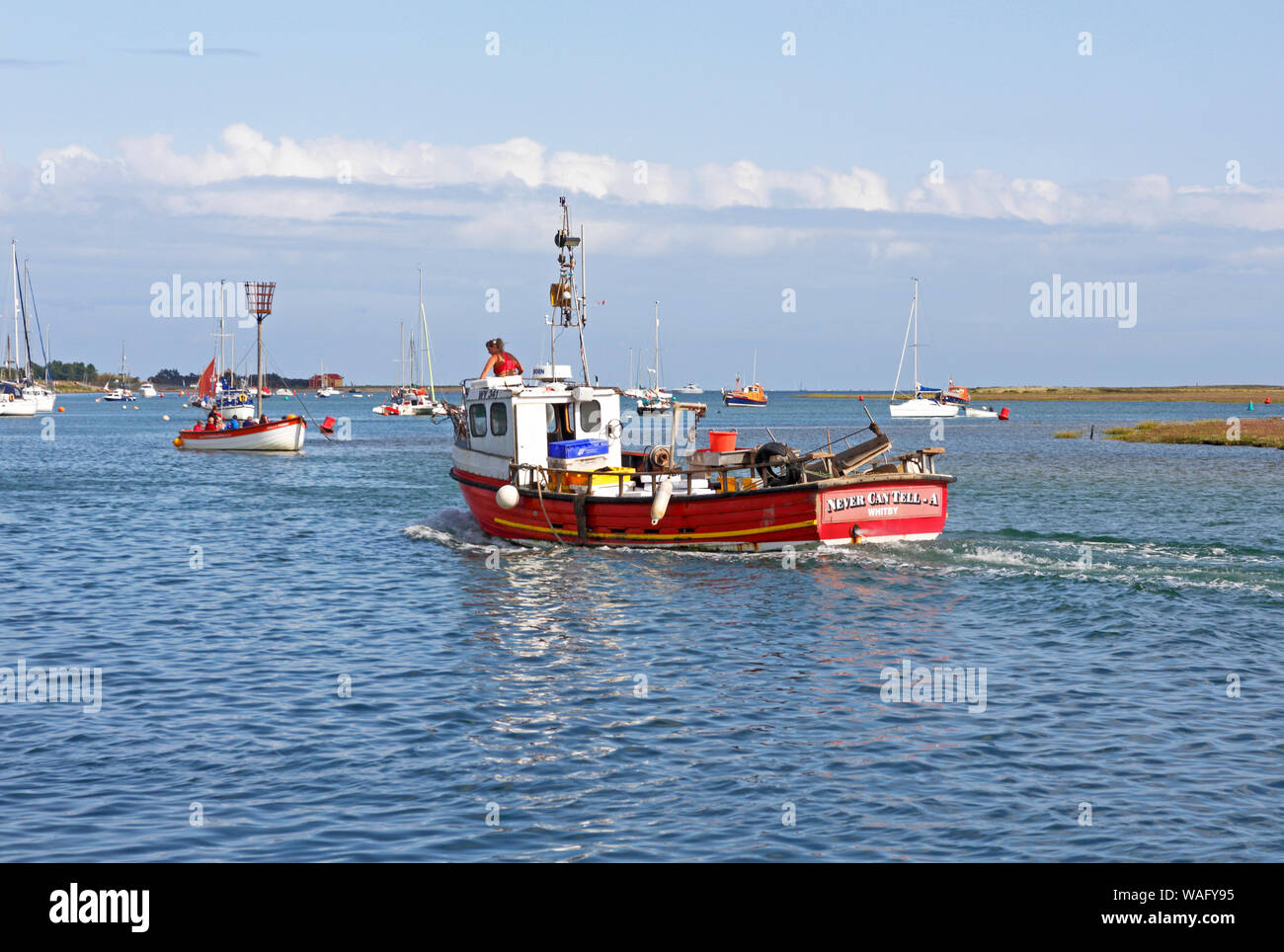 An inshore fishing boat heading out from the North Norfolk port of Wells-next-the-Sea, Norfolk, England, United Kingdom, Europe. Stock Photo