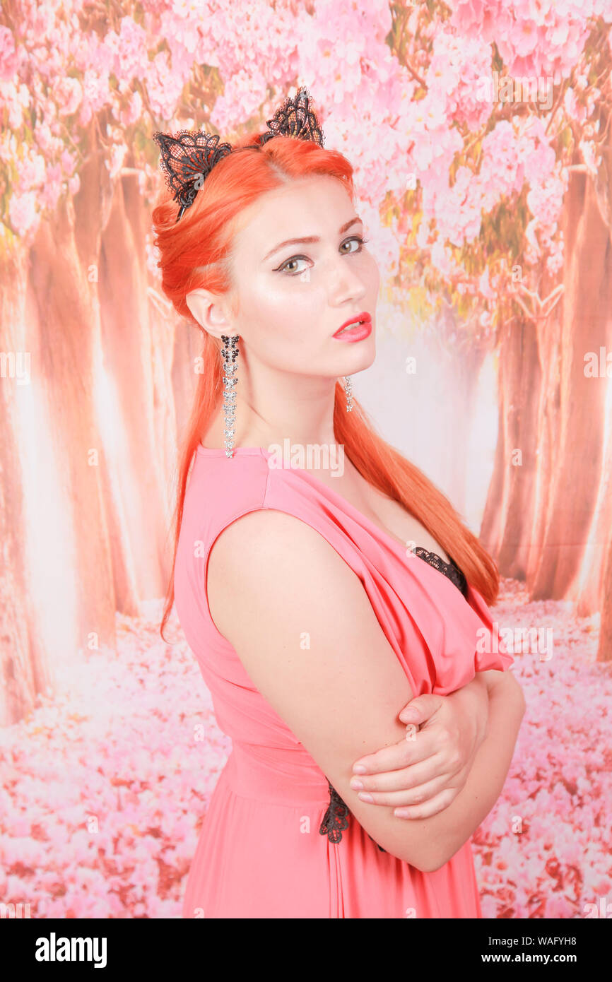 pretty woman in trendy coral color red evening dress Stock Photo