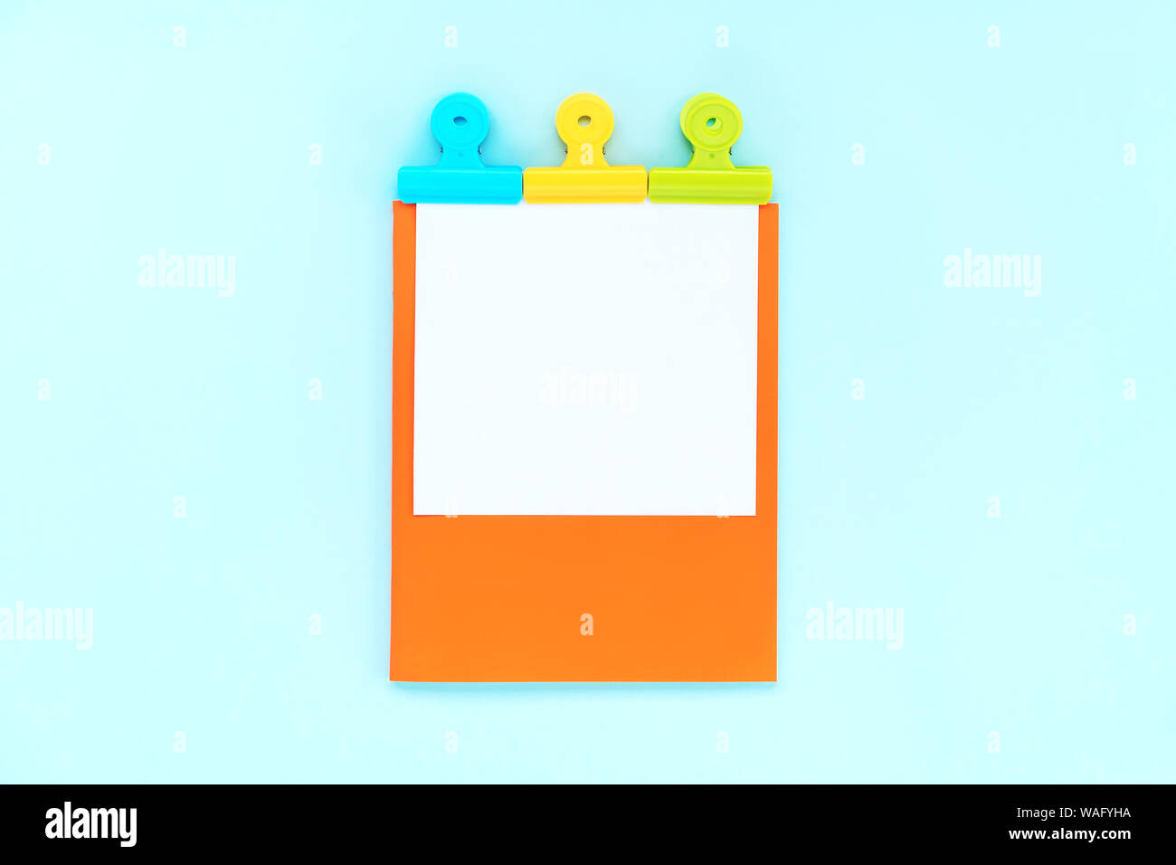 A white sheet for writing on an orange notebook  Stock Photo