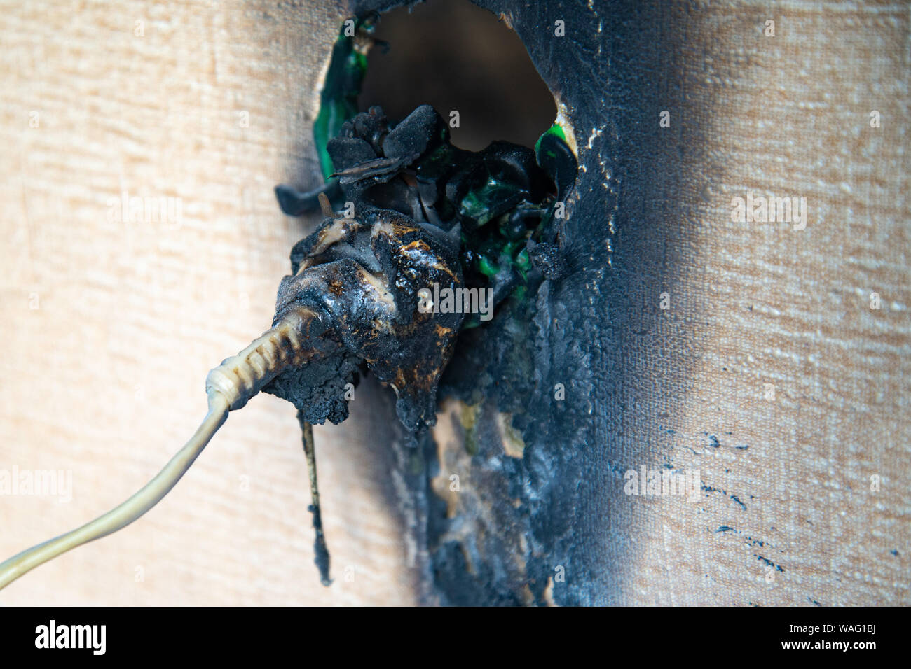 Burnt power outlet. Melted-off and burned plastic socket of power supply. Stock Photo