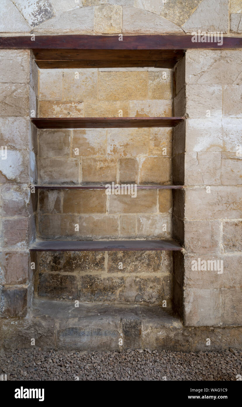 Recessed frame, Niche with wooden shelves in an old weathered stone