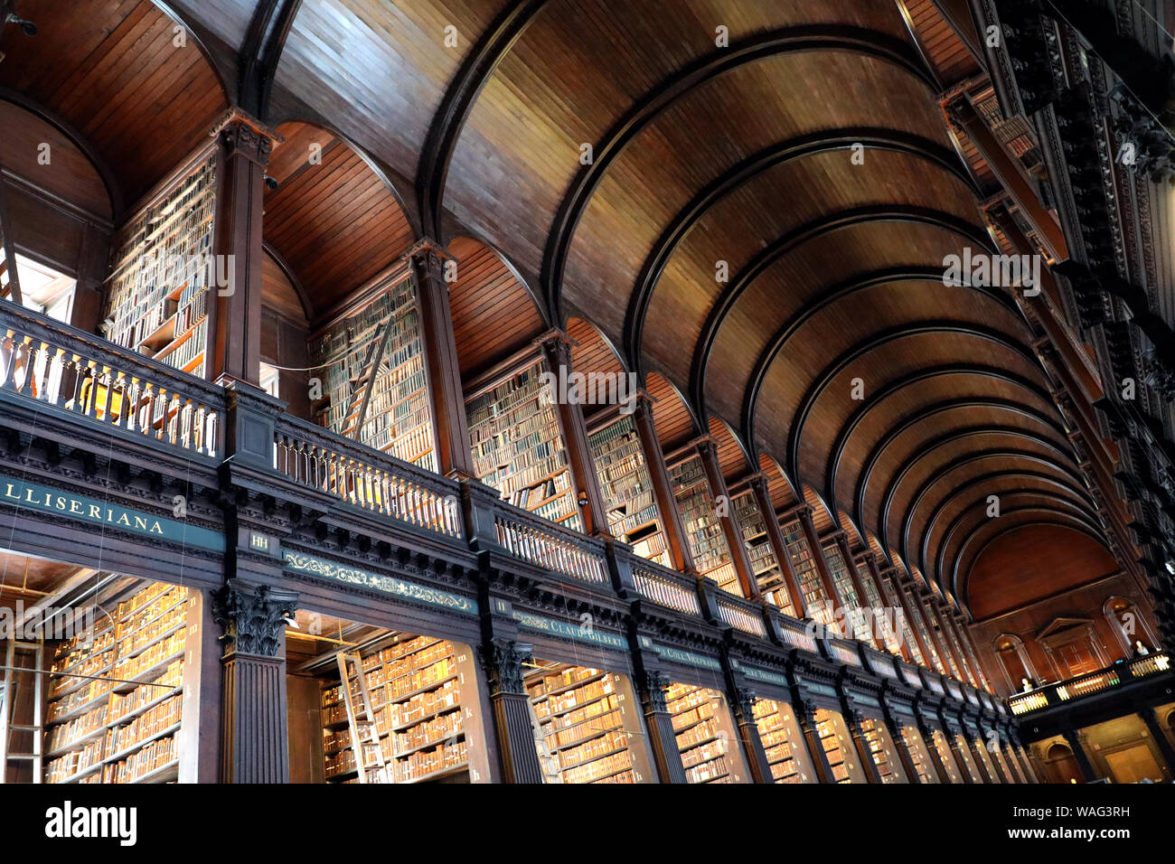 Image of the old library of Trinity College in Dublin, all made of wood, with old books and images of great thinkers of all times. Stock Photo