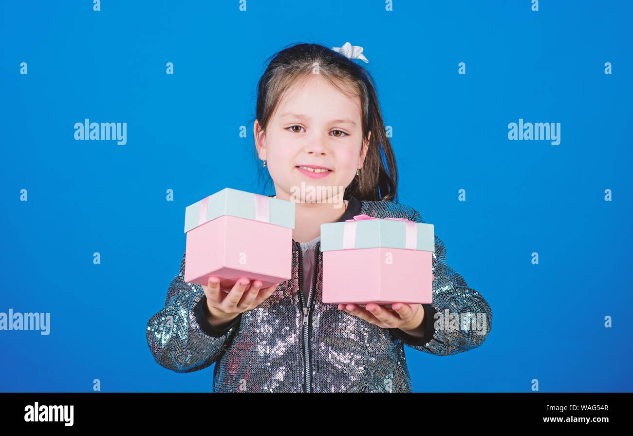 Choose one. Girl with gift boxes blue background. Black friday. Shopping day. Cute child carry gift boxes. Surprise gift box. Birthday wish list. World of happiness. Special happens every day. Stock Photo
