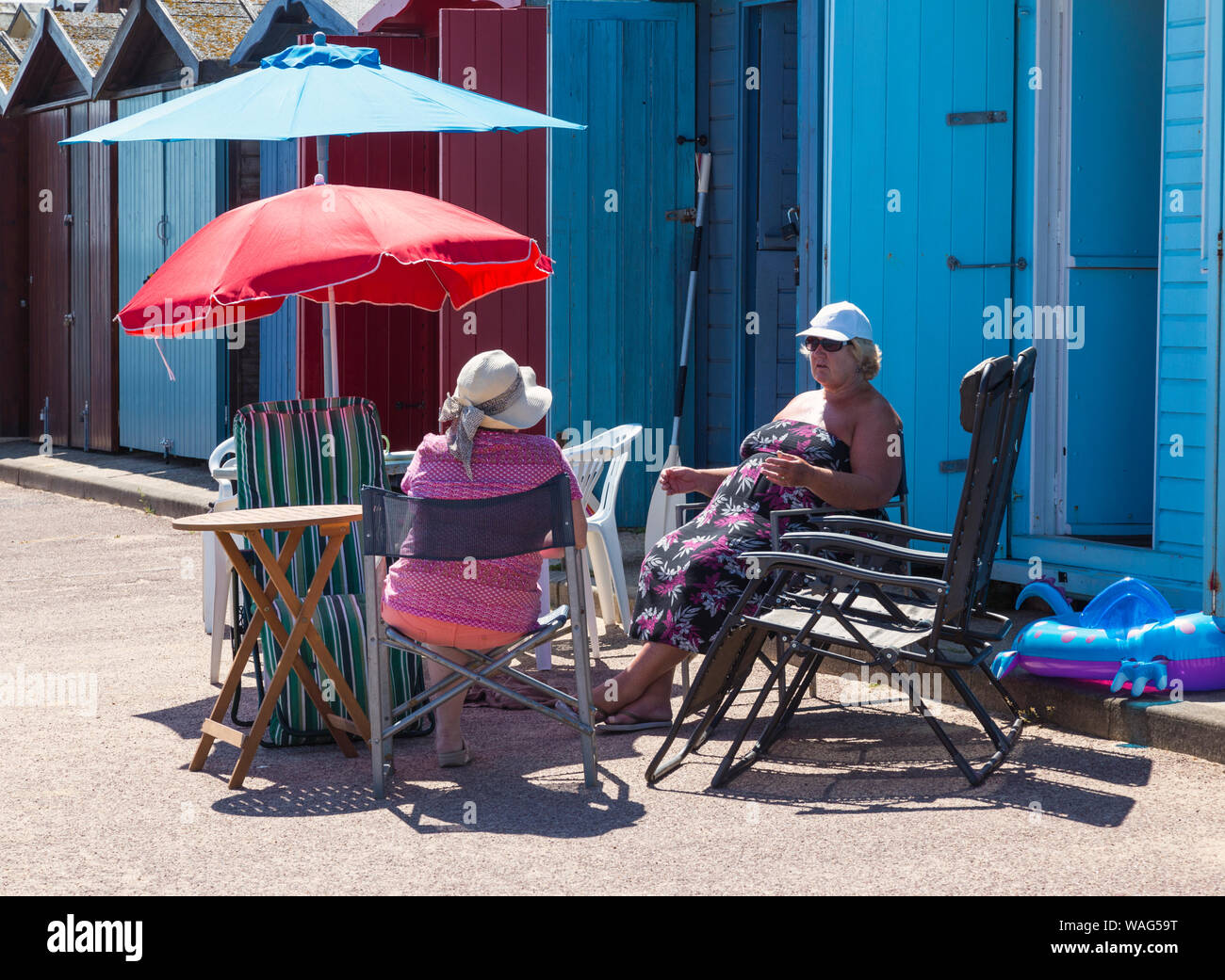 Chatting by a seaside beach hut Stock Photo