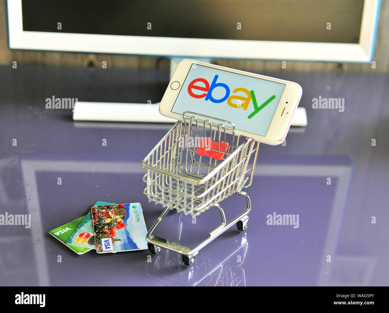 Yaroslavl, Russia - August 20, 2019: Mobile phone with ebay logo in shopping cart and credit cards on the table. Stock Photo