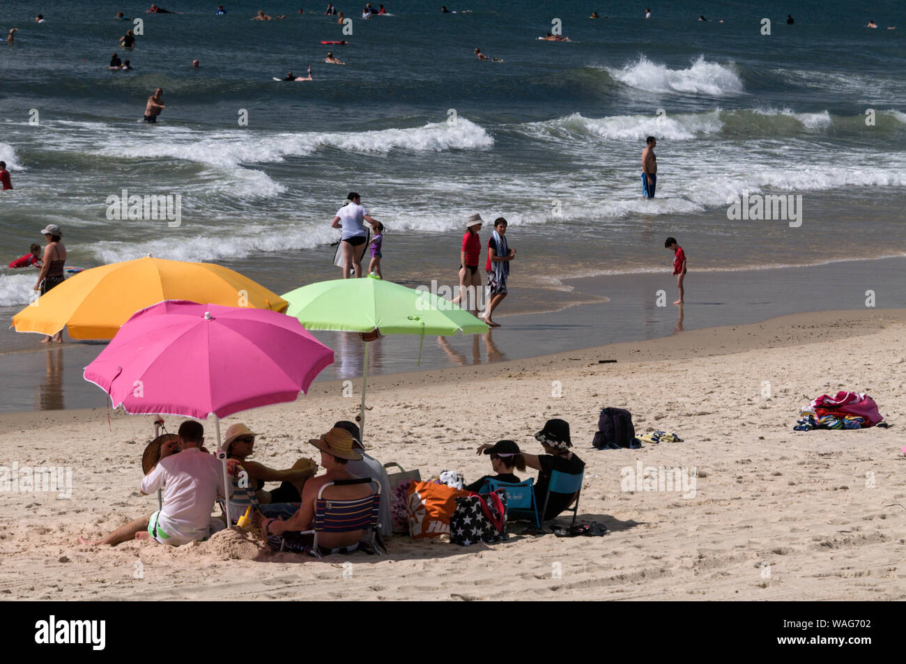 Bathers using their umbrellas as sun shades whilst enjoying the hot