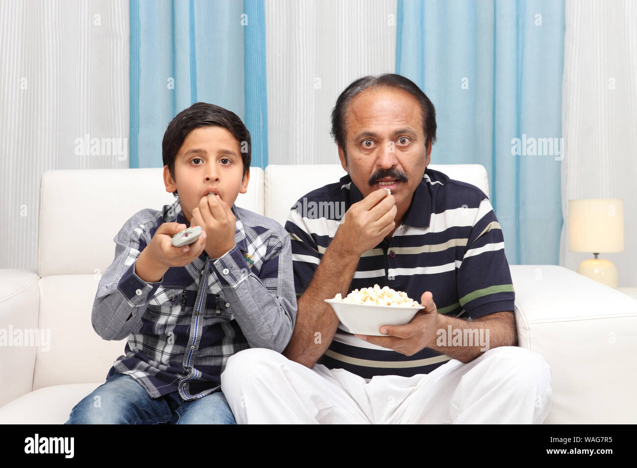 Old man with his grandson watching television Stock Photo