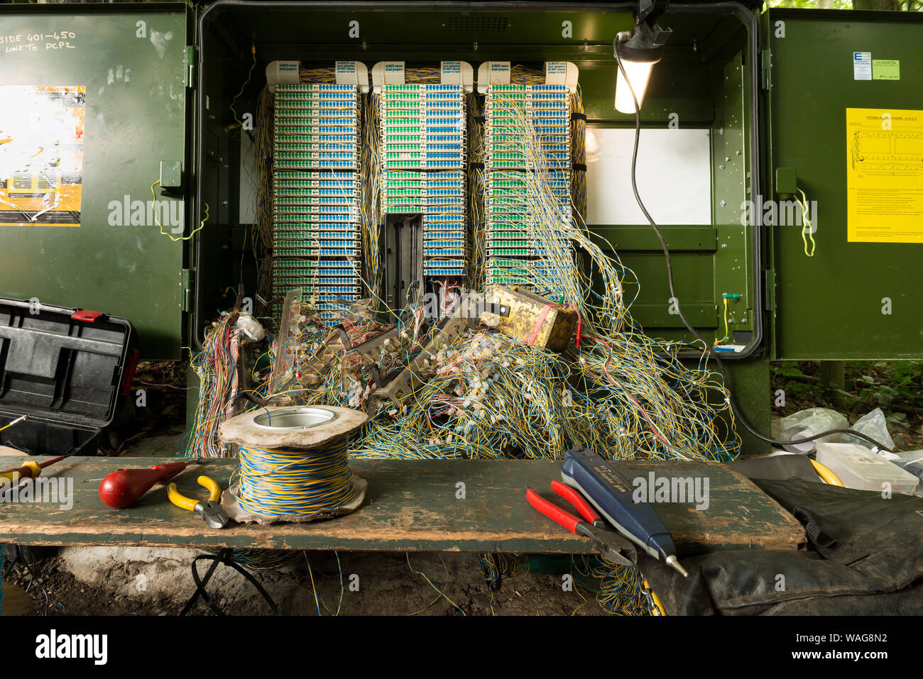 Muddled mass of twisted phone wires in a network box being repaired on