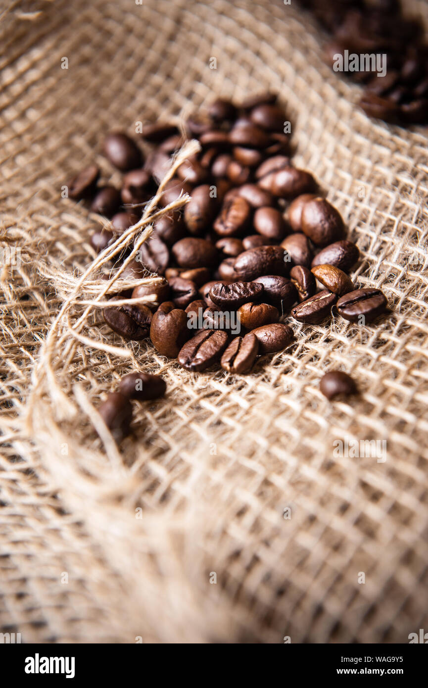 sprinkled roasted coffee beans on burlap Stock Photo