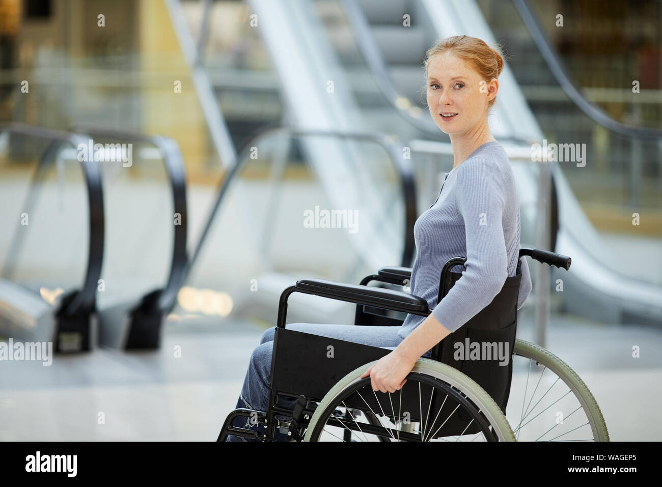 Portrait of young disabled businesswoman sitting in wheelchair and ...