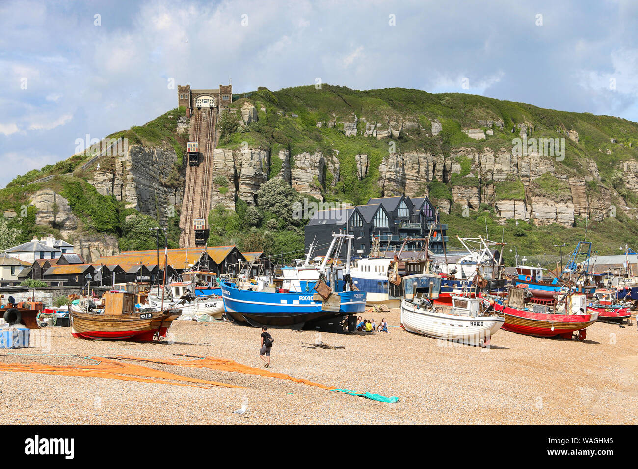 Fishing boats with paraphenalia on the shingle beach of the Old Town, with the steep funicular railway int he background, Hastings, East Sussex, UK Stock Photo