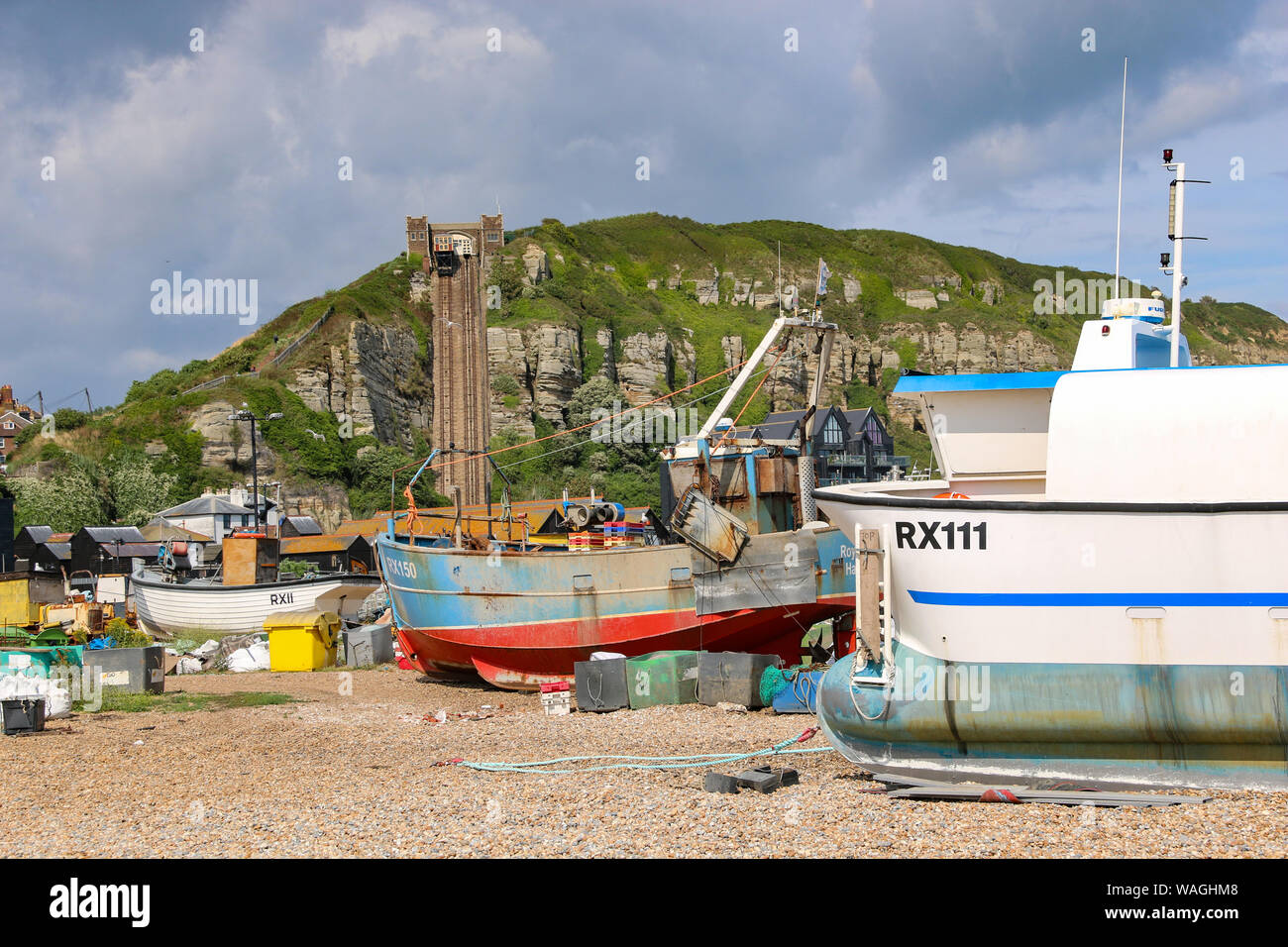 Fishing boats with paraphenalia on the shingle beach of the Old Town, with the steep funicular railway int he background, Hastings, East Sussex, UK Stock Photo