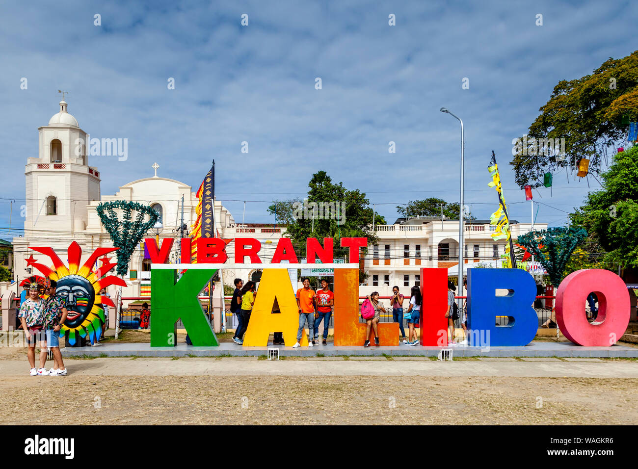 Visitors Pose In Front Of A Vibrant Kalibo Sign During The AtiAtihan