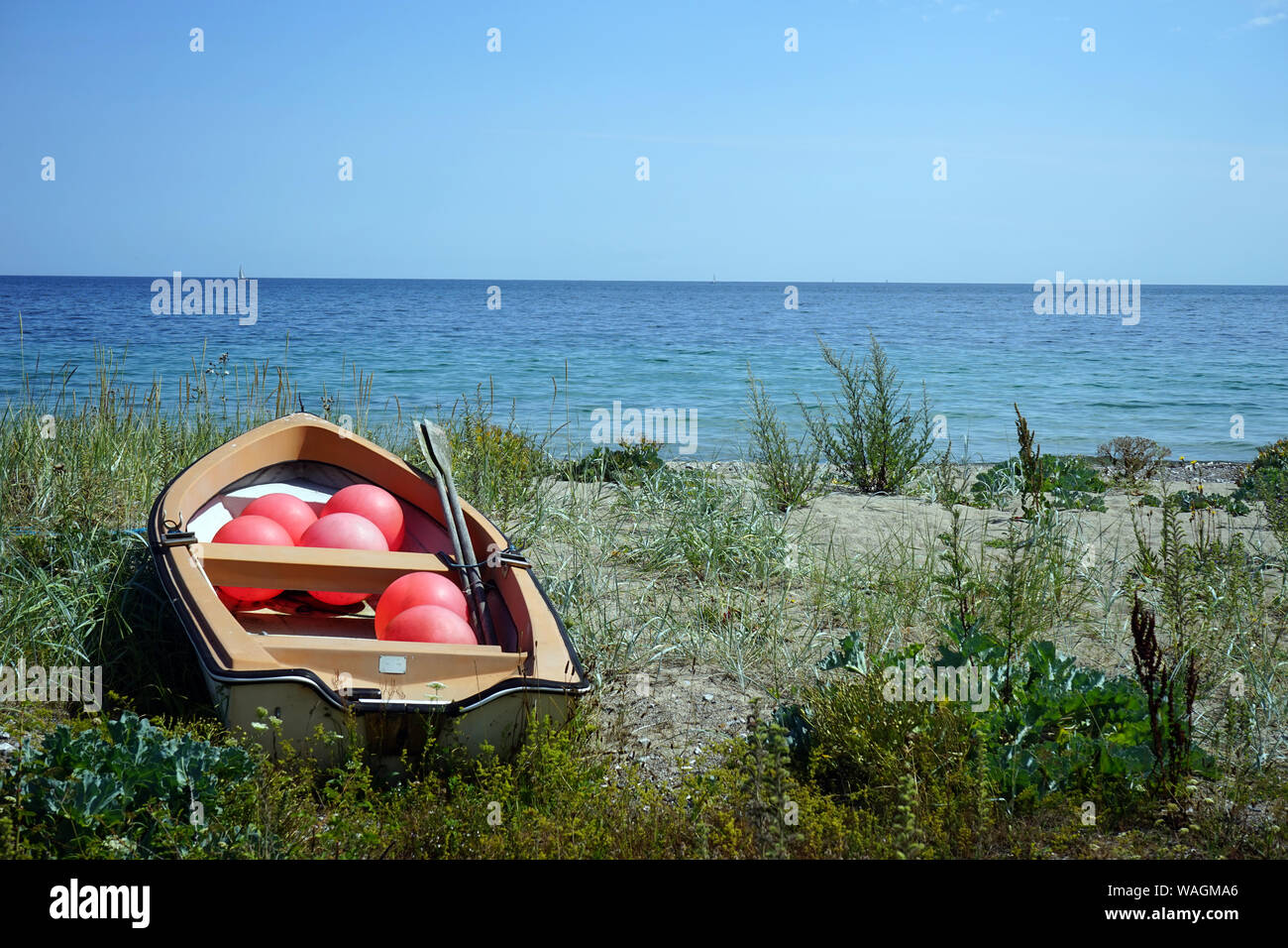 Red balls in wooden boat on the coast Stock Photo