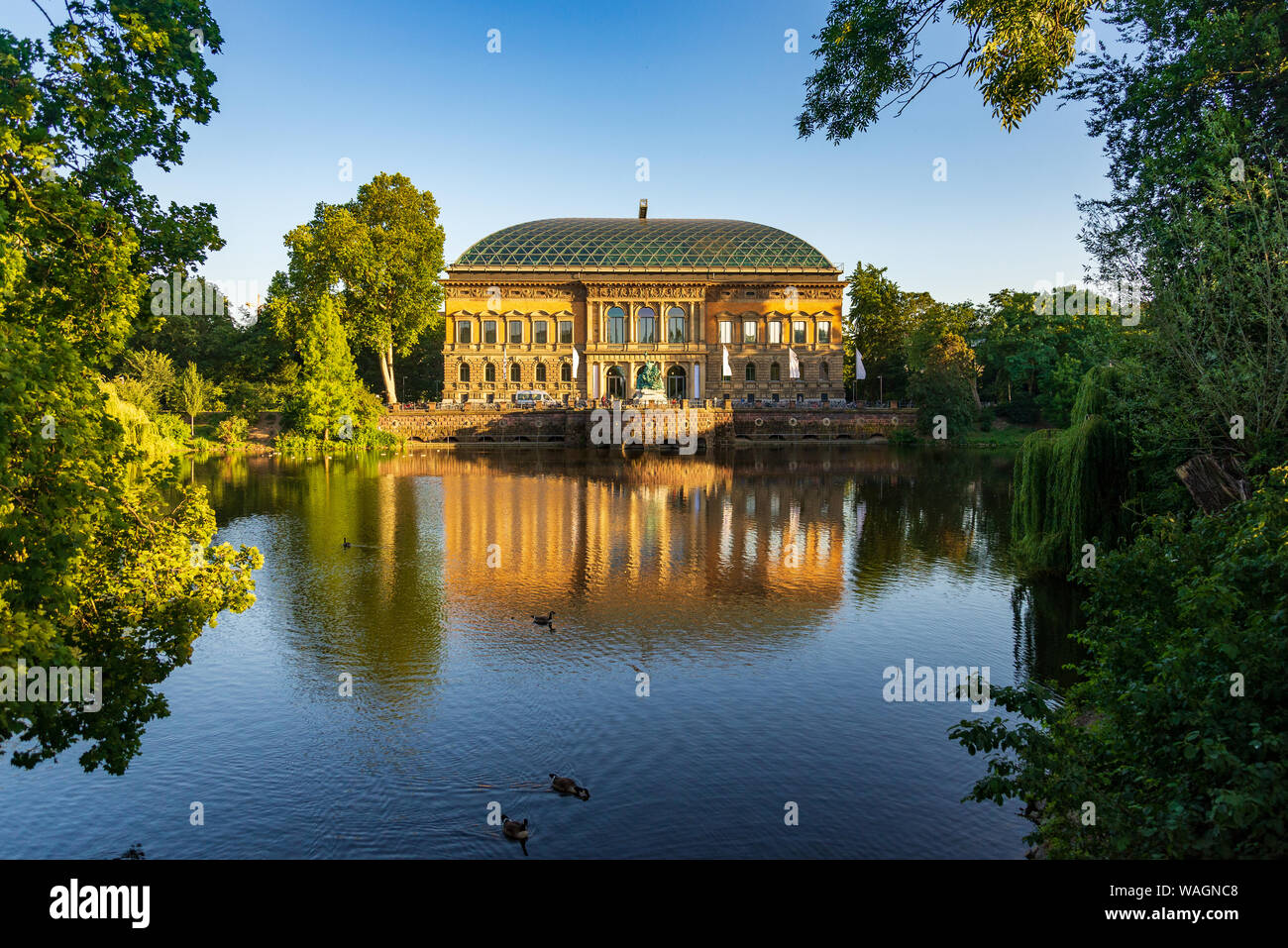 Outdoor view with golden light at Ständehaus park with reflection on the lake, and background of K21-Kunstsammlung, Modern Art Museum. Stock Photo