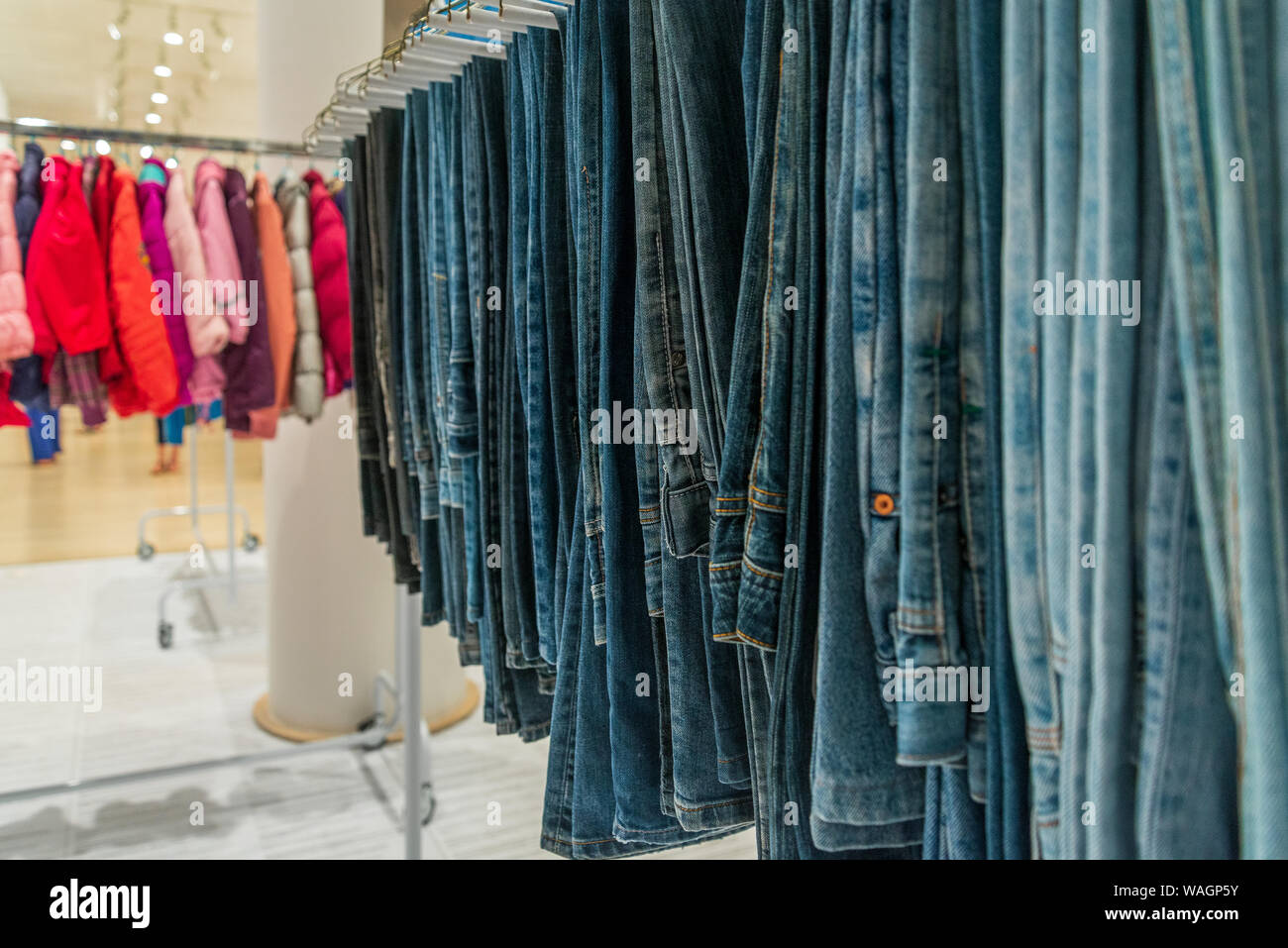 Close up view at row of jeans or denim trousers and slacks hang on hanger  inside fashion clothes outlet or second hand store Stock Photo - Alamy