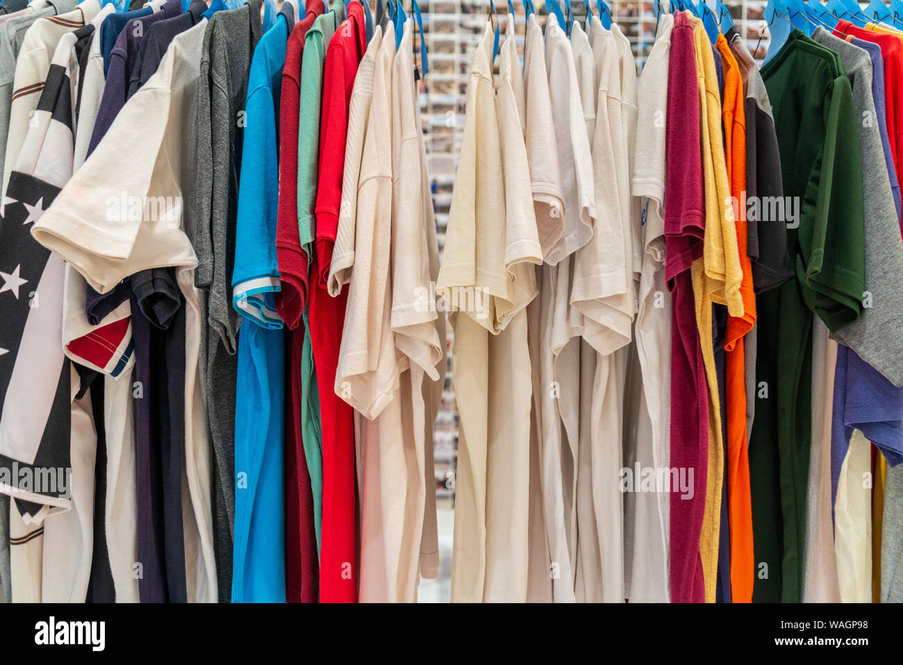 Row of colourful tone and white of T-shirts hang on aluminium hanger  clothes rack in retail fashion store or second hand outlet shop Stock Photo  - Alamy