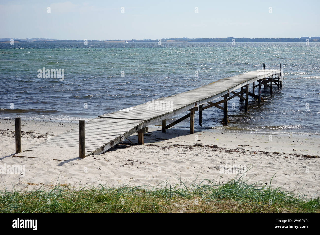 Wooden pier and sand beach on the Baltic sea coast of Denmsark Stock Photo