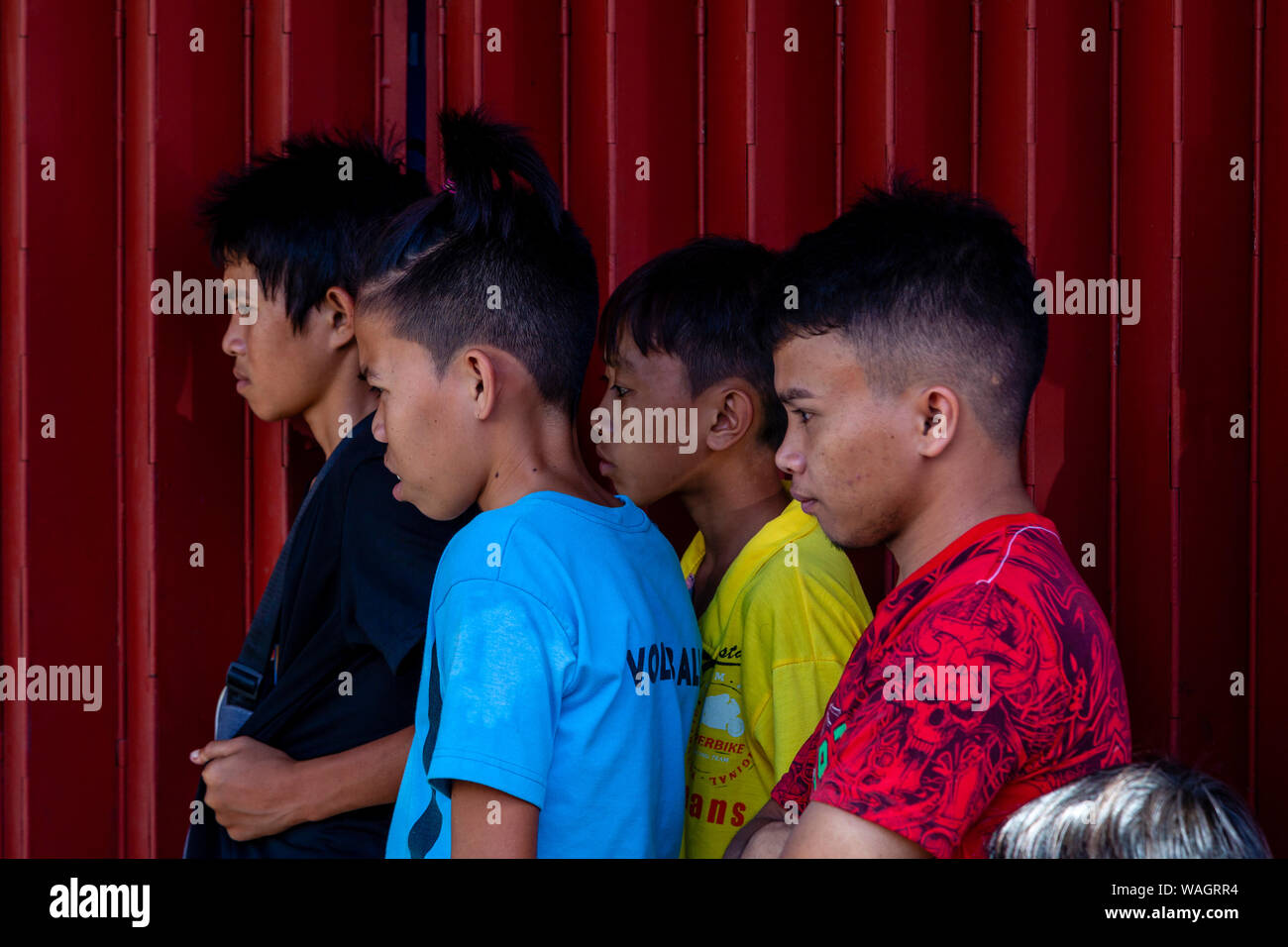 A Group of Filipino Boys Watch A Street Entertainer In Kalibo, Panay Island, Aklan Province, Western Visayas, The Philippines. Stock Photo
