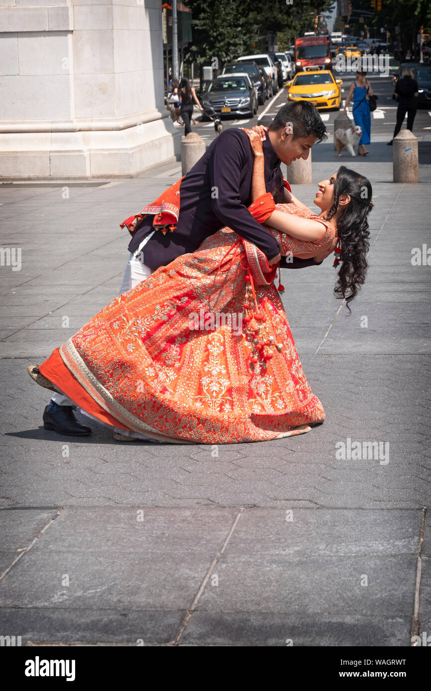 an attractive hindu couple pose for pre wedding photos under the arch in washington square park in greenwich village manhattan new york city WAGRWT