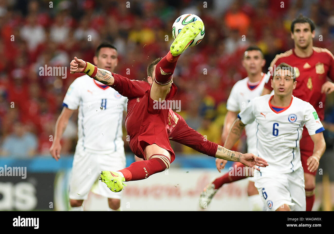 Rio de Janeiro, June 18, 2014. Football player Sergio Ramos hits a volley during the match, Spain vs Chile, for the 2014 World Cup at the Maracanã Sta Stock Photo
