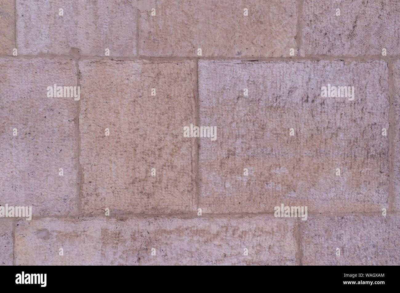 beige weathered granite stone tiled wall background. texture. Stock Photo