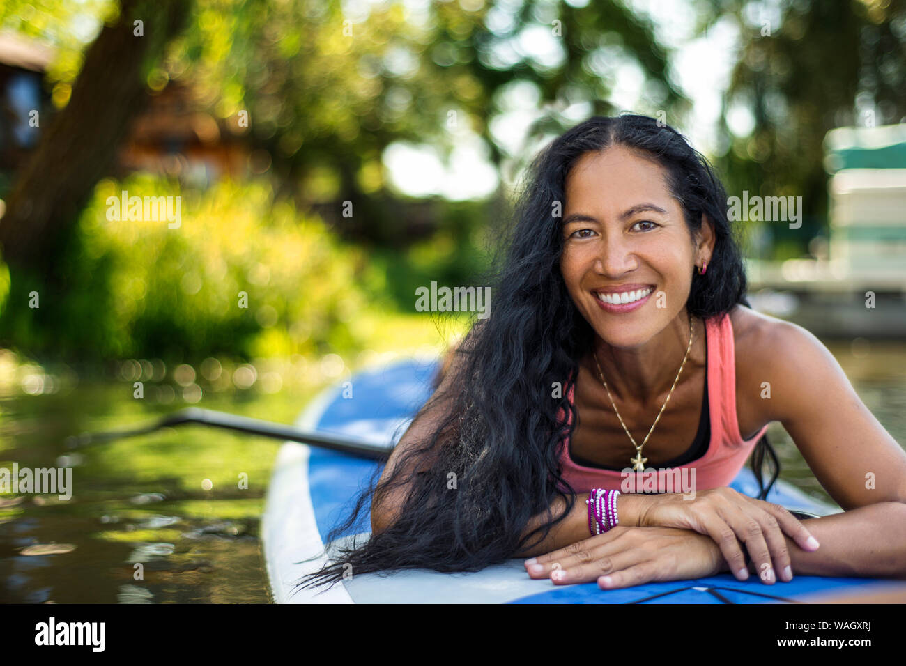 Mid adult woman prepares for paddleboarding. Stock Photo