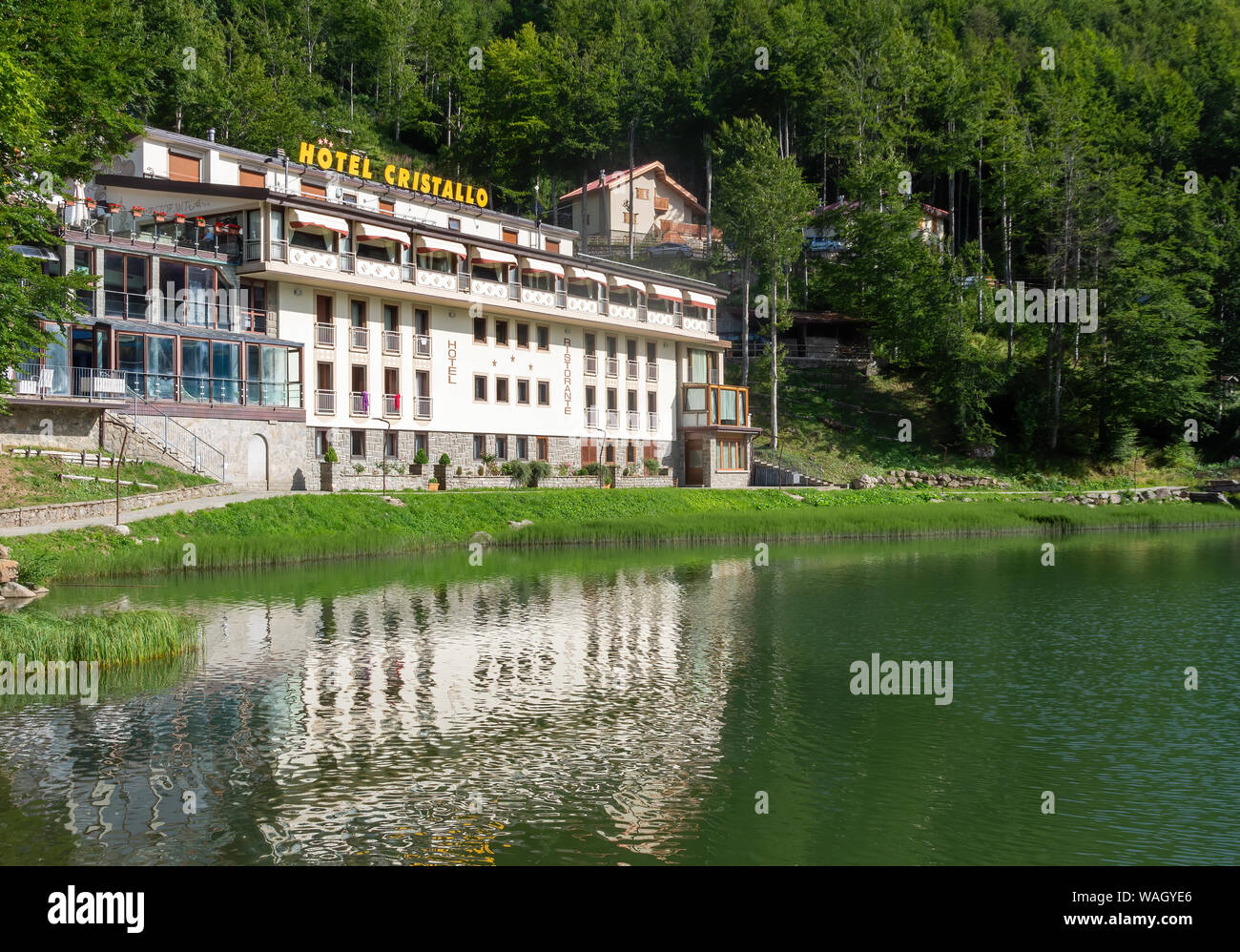 CERRETO LAGHI, ITALY – AUGUST 11, 2019: Near Cerreto Pass in the Apennines, the area is known as a ski resort. Here the Cristallo Hotel and the lake Stock Photo