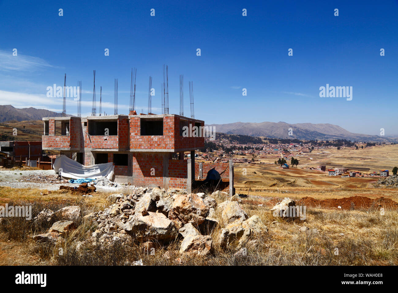 Building under construction at Nuevo Chinchero, near the original village of Chinchero (in background), financed by compensation for land bought by the government from familiies for the construction of a new airport for Cusco and Machu Picchu, Cusco Region, Peru Stock Photo
