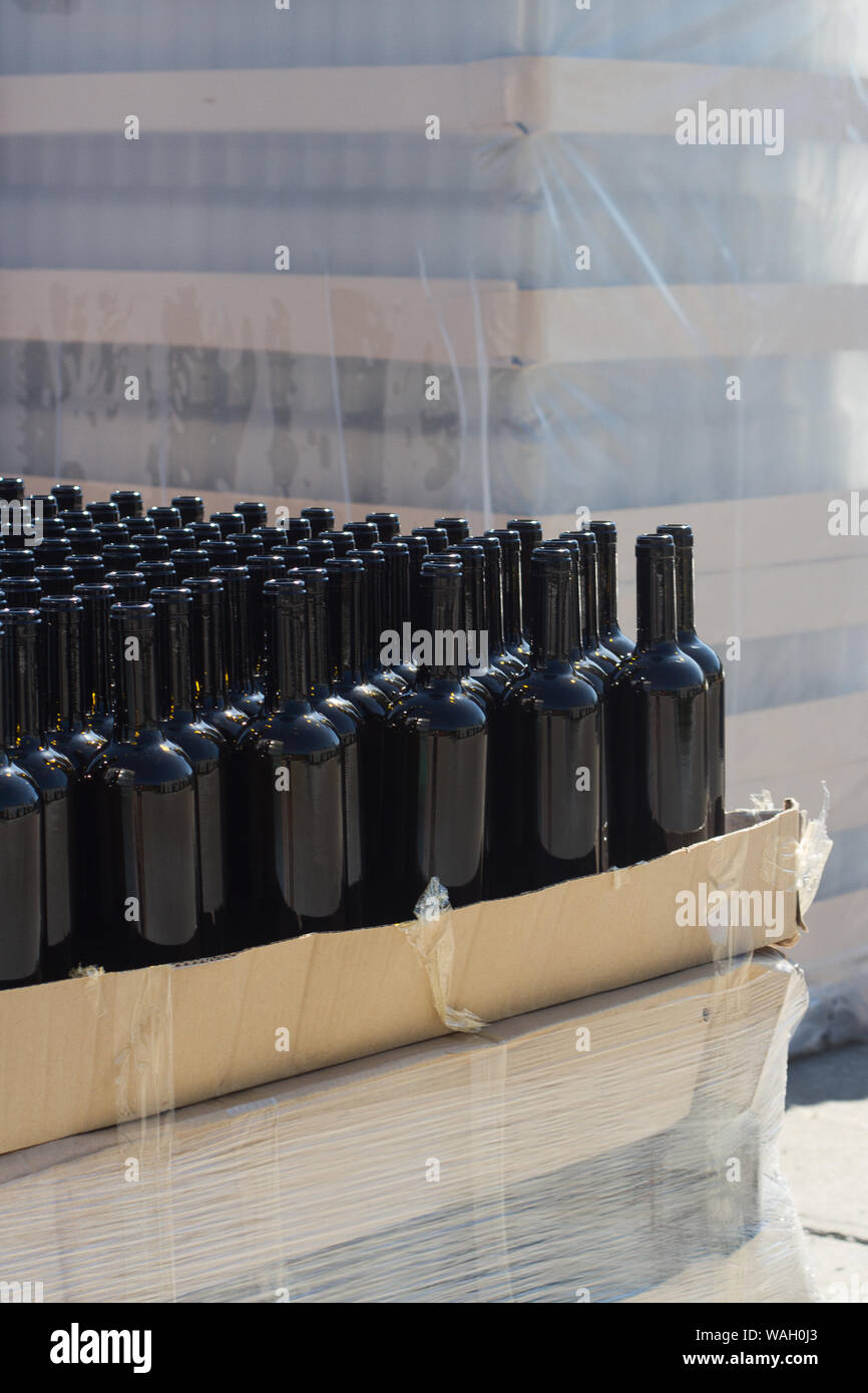 vertical side view closeup of many black empty wine bottles arranged in rows and stacked on transport pallets in outside storage area Stock Photo Alamy