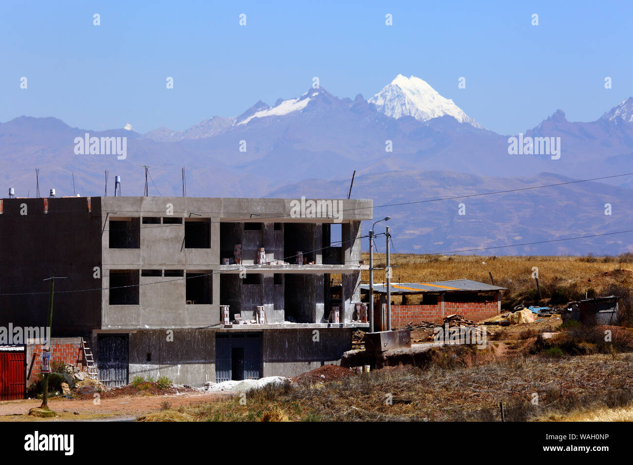 Buildings under construction at Nuevo Chinchero, near the original village of Chinchero, financed by compensation for land bought by the government from familiies for the construction of a new airport for Cusco and Machu Picchu. Mt Salcantay is in the background. Cusco Region, Peru Stock Photo