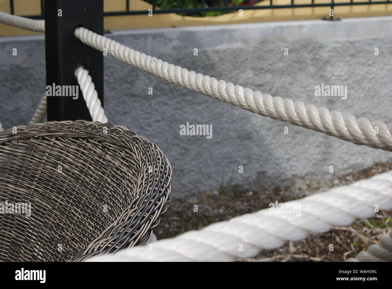 Un fauteuil en rotin et une grosse corde blanche Stock Photo - Alamy