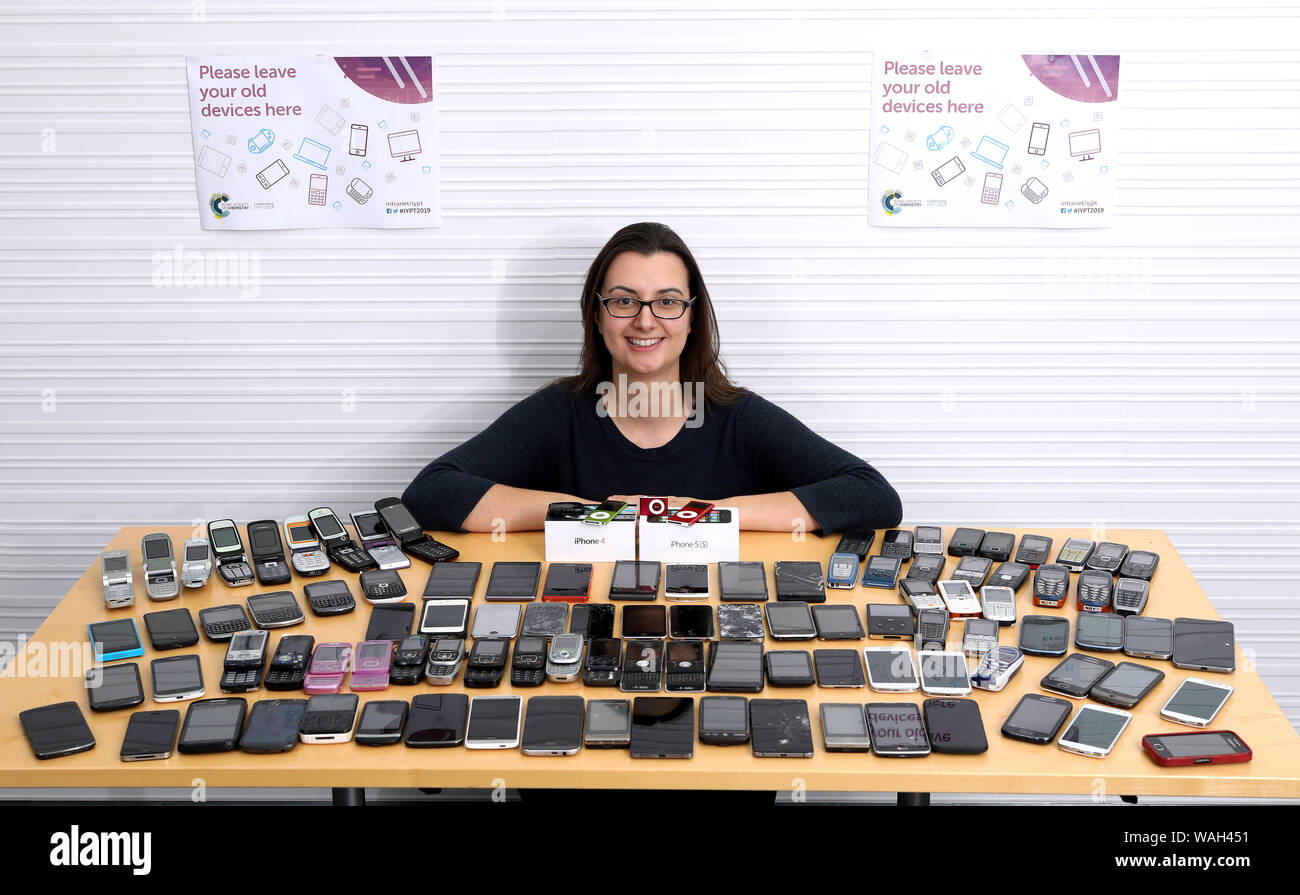 Lizzy Ratcliffe of the Royal Society of Chemistry, with some of the redundant tech gathered by staff at the organisation's Cambridge HQ during an amnesty. Stock Photo