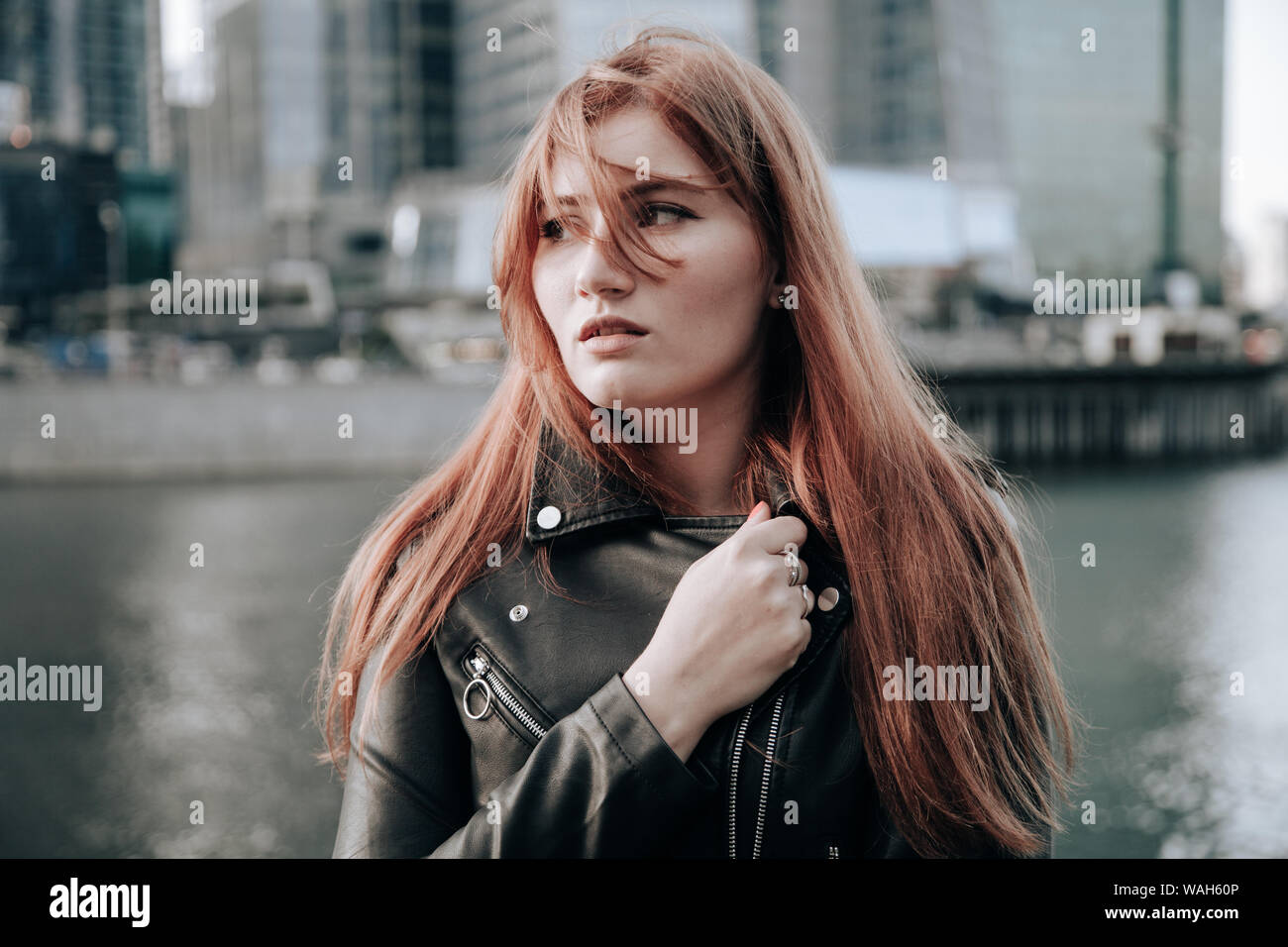 plus size woman with red hair wearing blue dress and leather black jacket Stock Photo