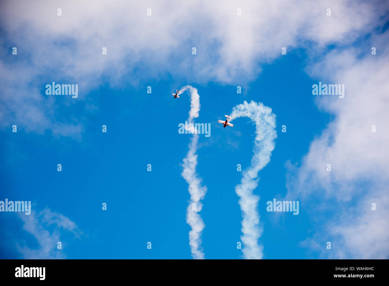 Extra 300 Duo display at airshow including smoke trails, formation, synchronized dive with radio controlled miniature version Stock Photo