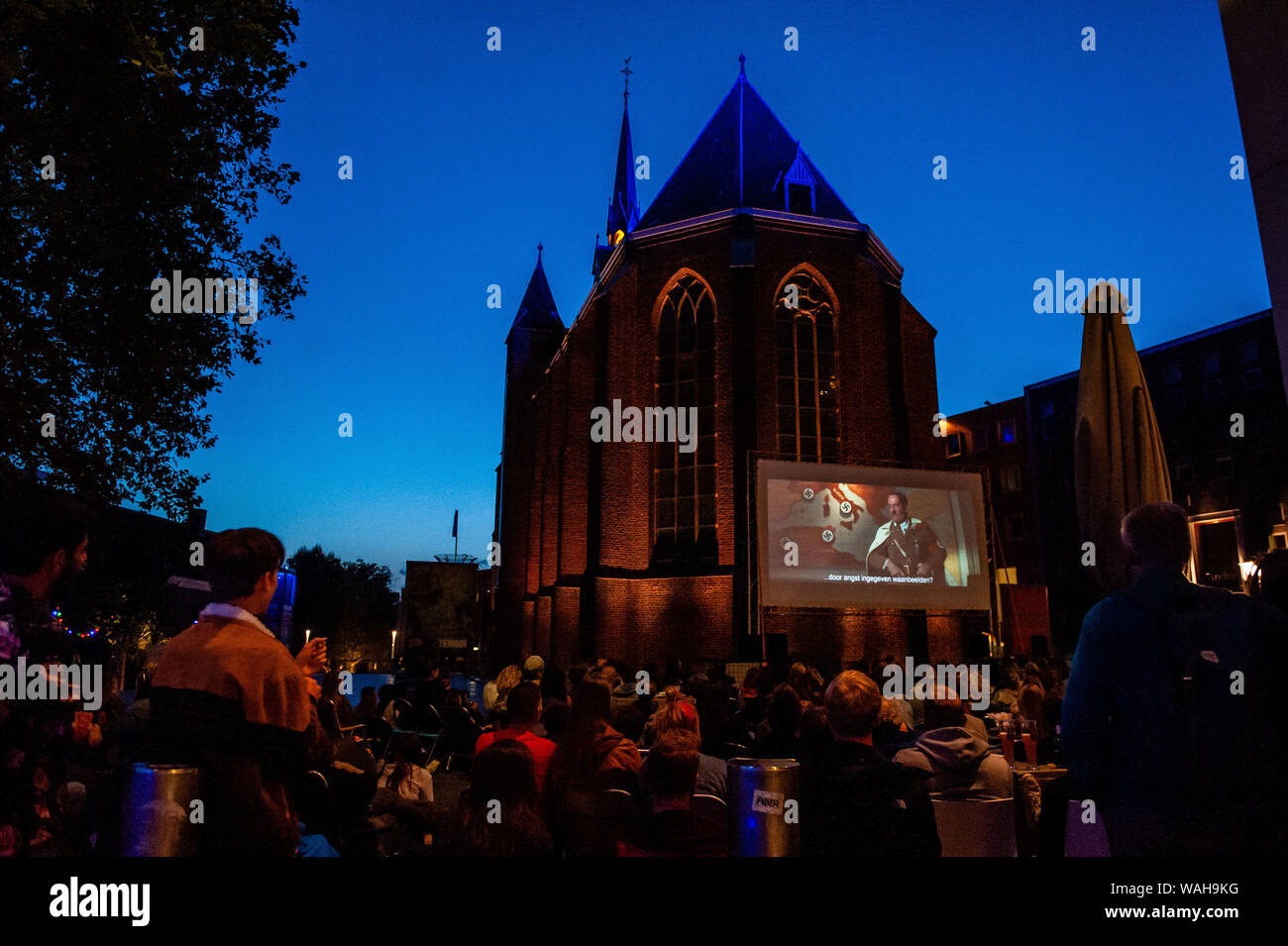 Nijmegen, Gelderland, Netherlands. 20th Aug, 2019. A big screen is being situated outside the church.Because the last film of Quentin Tarantino was released this month, LUX an independent and liberal platform in Nijmegen for new developments in art and culture offered an open-air cinema screenings of his well-known films, like Four Rooms and Pulp Fiction. Hundreds of people could enjoy for free the movies, like Four Rooms and Pulp Fiction in a very Tarantino style. Credit: Ana Fernandez/SOPA Images/ZUMA Wire/Alamy Live News Stock Photo