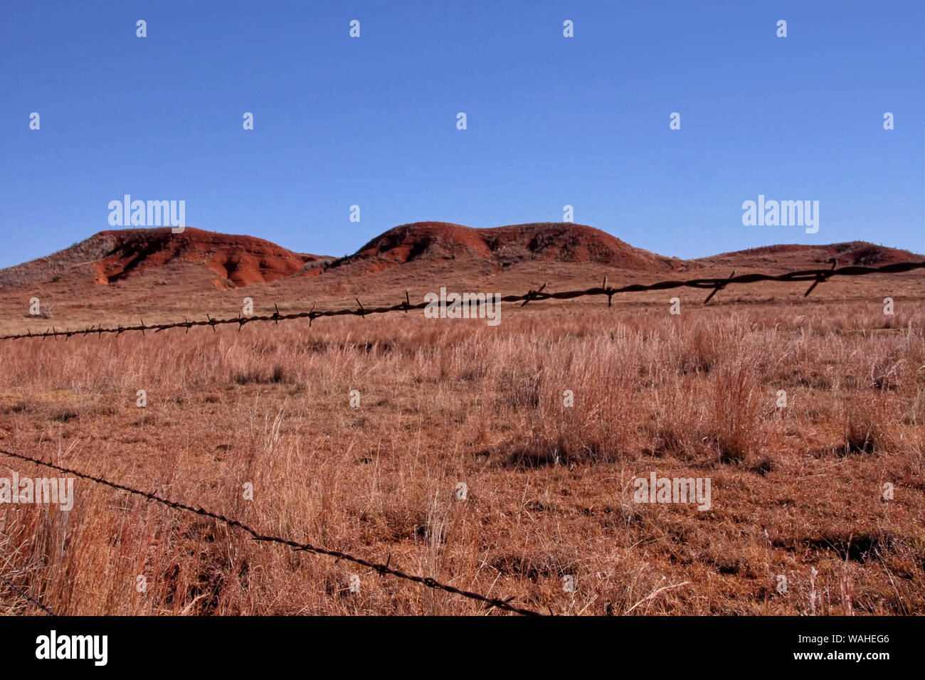 Red dirt hills and grassland of Western Oklahoma on a sunny day in late autumn. Stock Photo