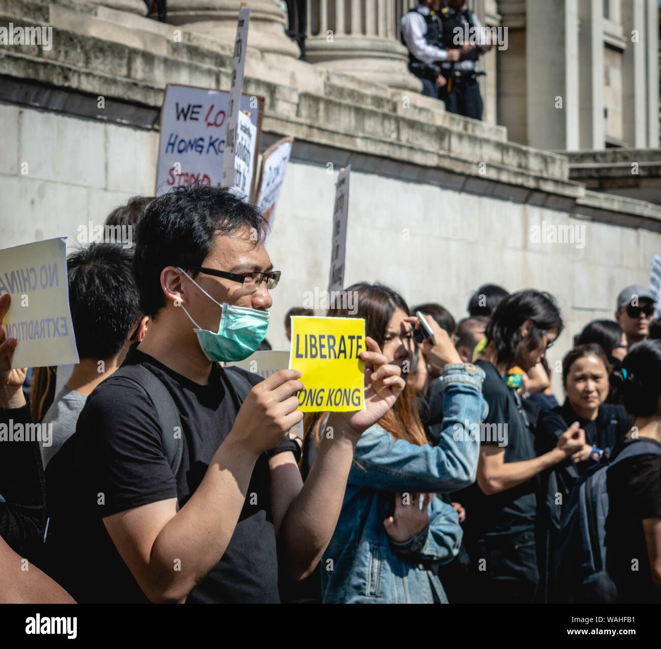 London, United Kingdom - August 17,  2019: Supporter of the UK Solidarity with Hong Kong rally holding a small banner saying 'Liberate Hong Kong.' Stock Photo