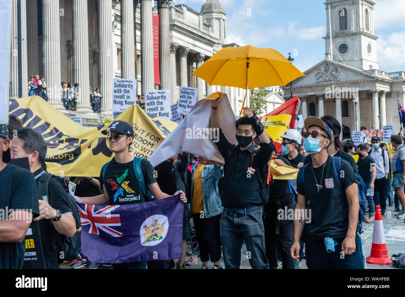 Protesters walking in a line at the UK Solidarity with Hong Kong rally. Stock Photo