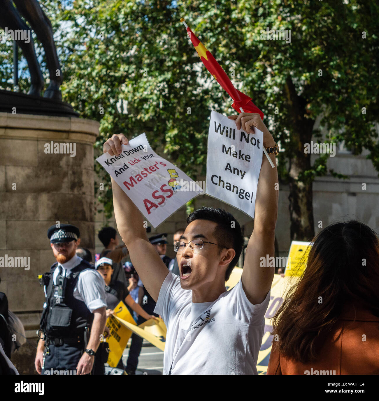 London, United Kingdom - August 17,  2019: Chinese man holding a banner against those supporting the UK Solidarity with Hong Kong Rally. Stock Photo