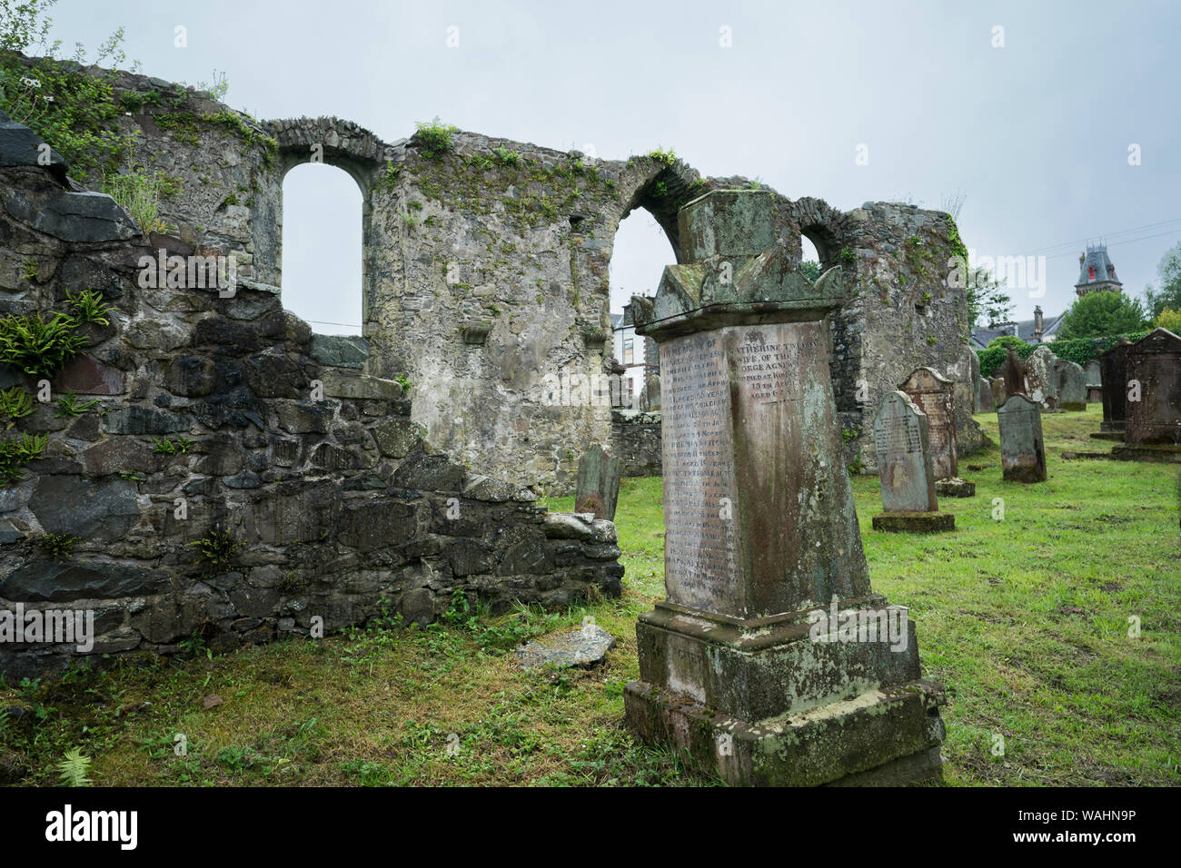 Ruined fragments of an ancient church among old gravestones in the cemetery of Wigtown Parish Church cemetery on a rainy day, Wigtown, Dumfries & Gall Stock Photo