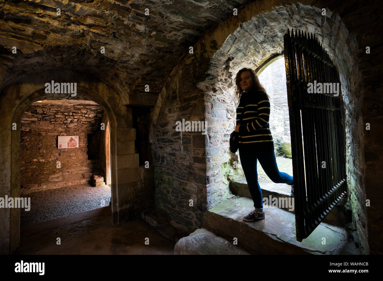 Teenage girl steps into the Priory catacombs where ancient Celtic crosses were found in the Birthplace of Christianity dating from 4th century, Whitho Stock Photo